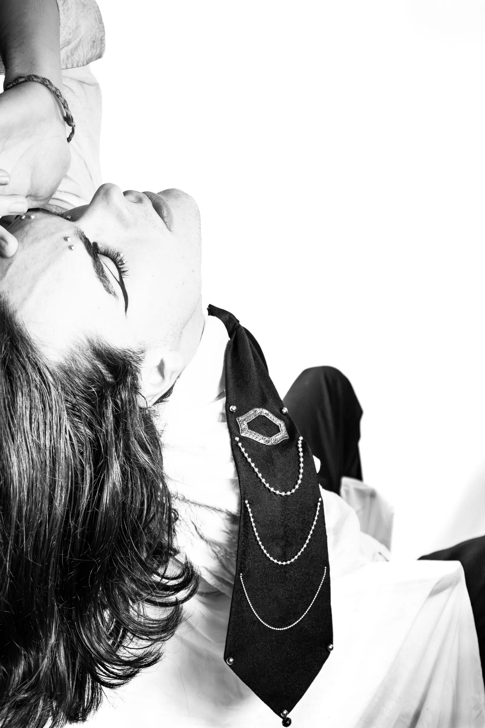 Portrait renversé en noir et blanc, costume sombre et bijoux