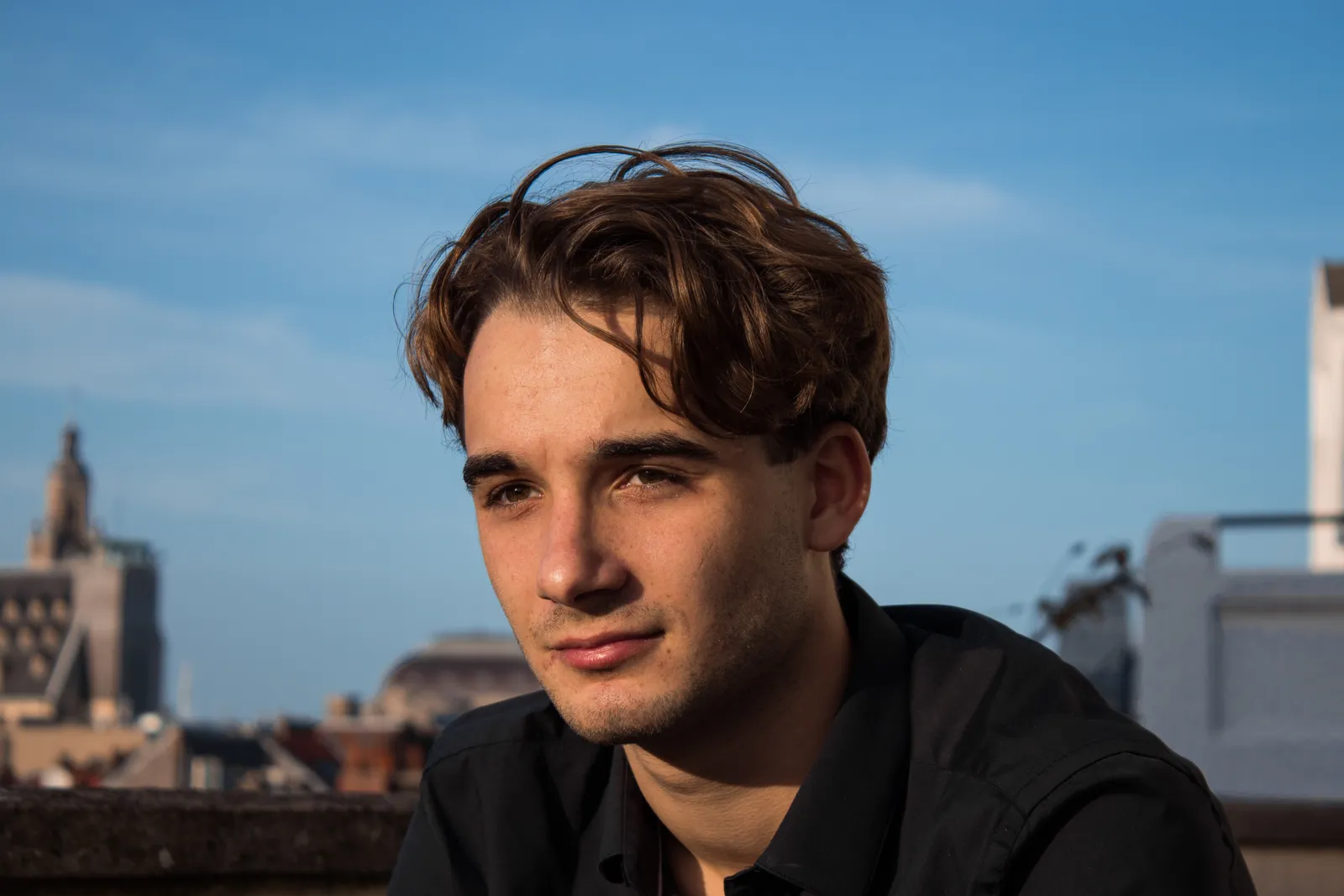 Portrait sur un toit, ciel bleu et ville en arrière-plan